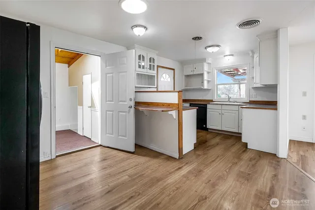 a kitchen with stainless steel appliances granite countertop a refrigerator a sink dishwasher and a stove with wooden floor