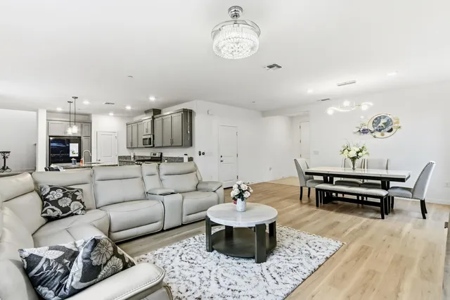 a living room with furniture kitchen view and a table