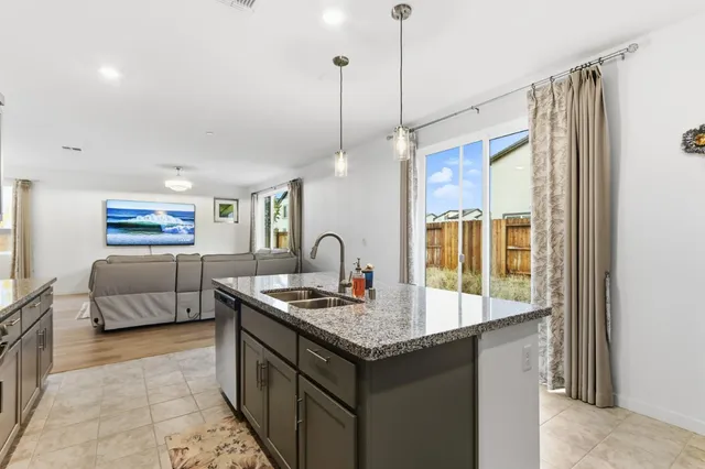 a kitchen with granite countertop a stove and a sink