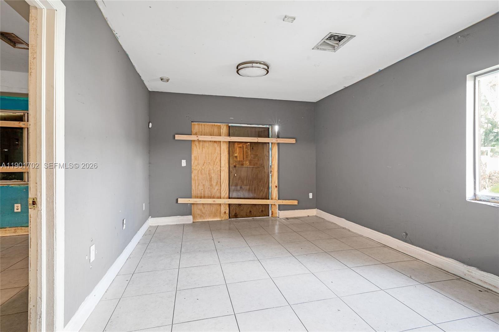 2951 Northwest 57th Street Miami, FL 33142 - Photo 12 of 24 a view of an empty room with a window
