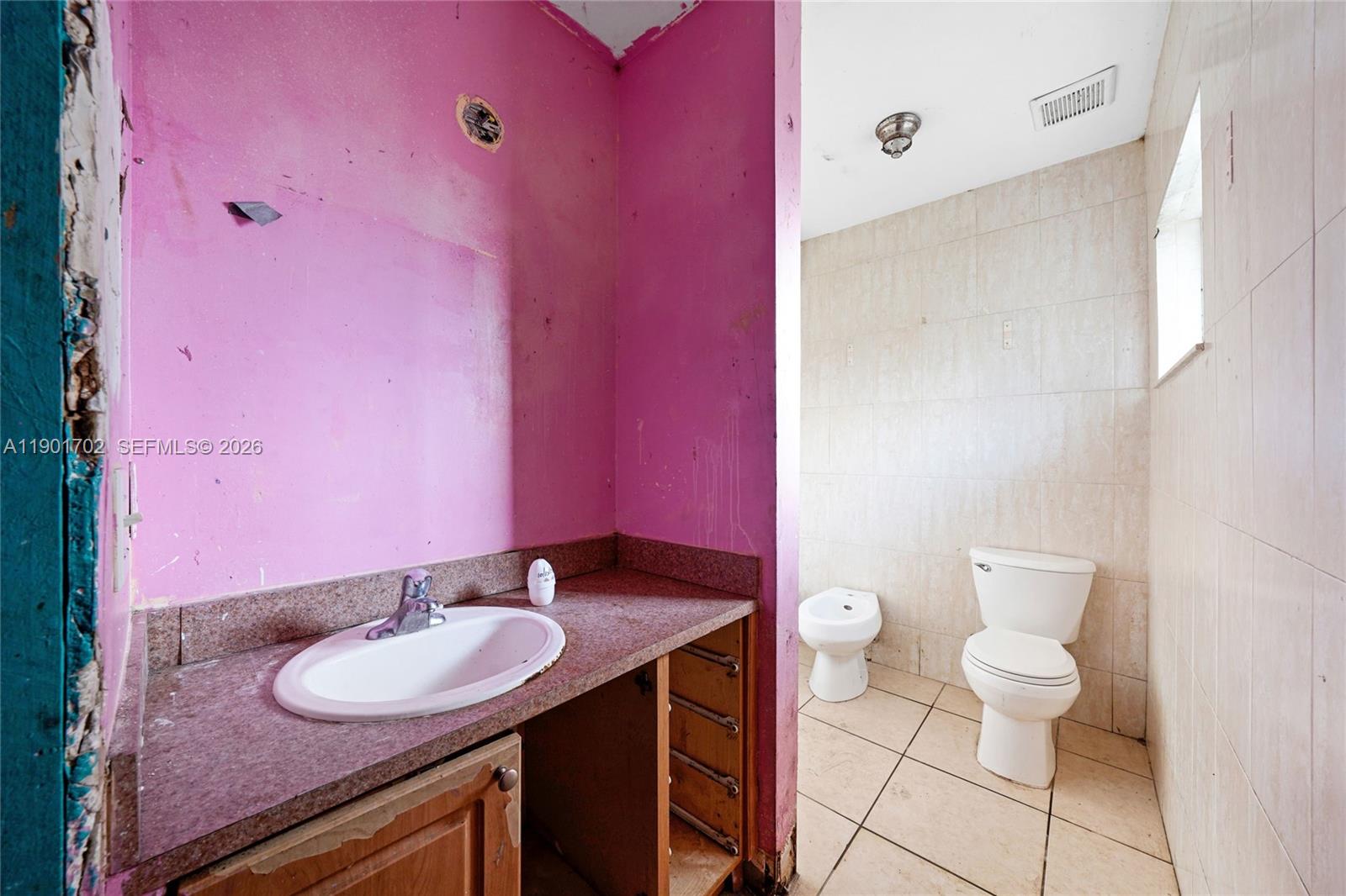 2951 Northwest 57th Street Miami, FL 33142 - Photo 15 of 24 a bathroom with a sink a toilet and a mirror