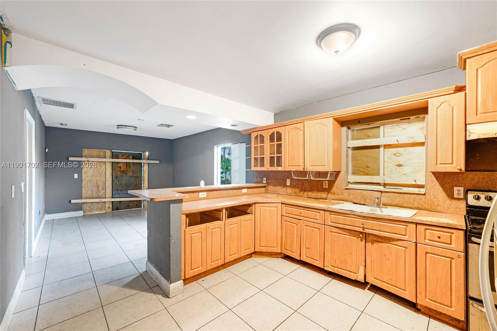 2951 Northwest 57th Street Miami, FL 33142 - Photo 5 of 24 a kitchen with a stove sink and cabinets