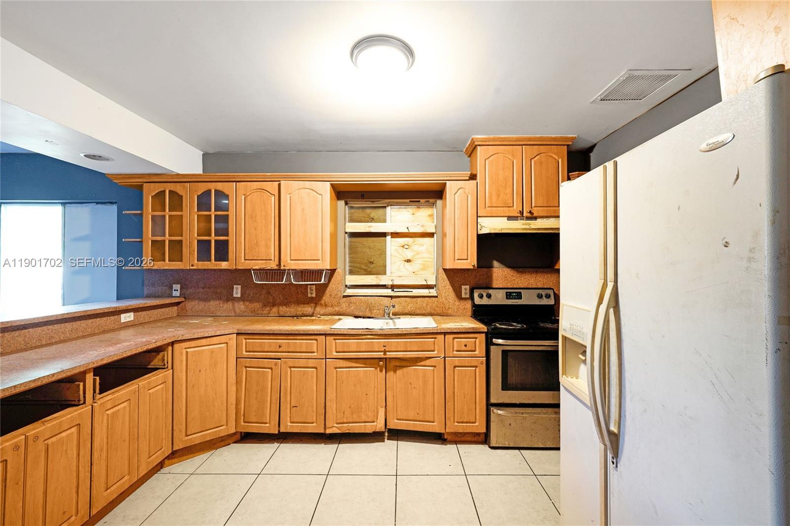 2951 Northwest 57th Street Miami, FL 33142 - Photo 6 of 24 a kitchen with stainless steel appliances granite countertop a sink and cabinets