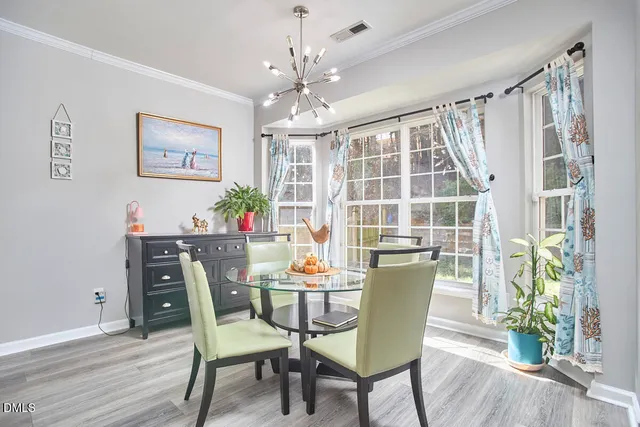 a view of a dining room with furniture a chandelier and wooden floor