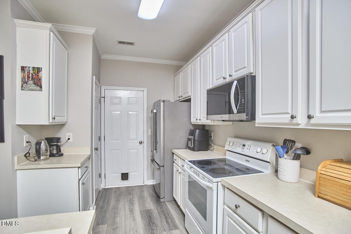 8441 Lunar Stone Place Raleigh, NC 27613 - Photo 21 of 43 a kitchen with stainless steel appliances granite countertop a sink stove and refrigerator