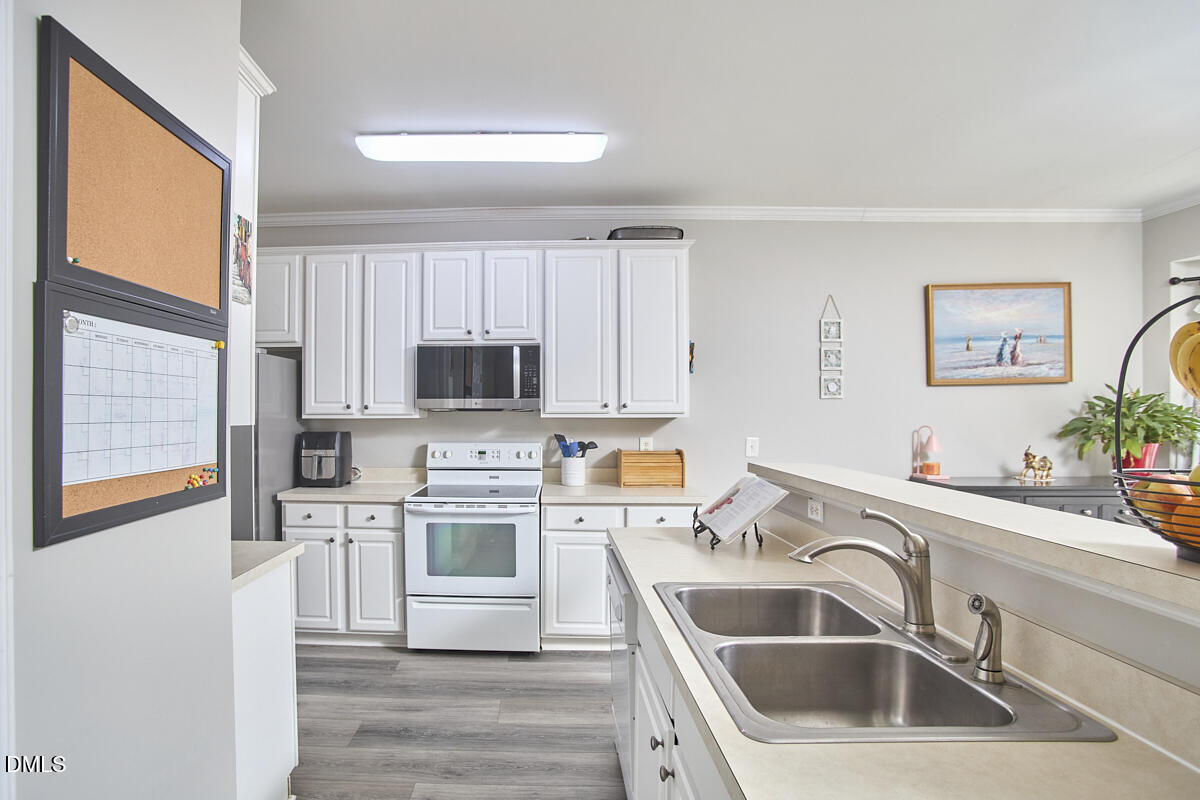 8441 Lunar Stone Place Raleigh, NC 27613 - Photo 23 of 43 a kitchen that has a sink and a stove top oven with white walls