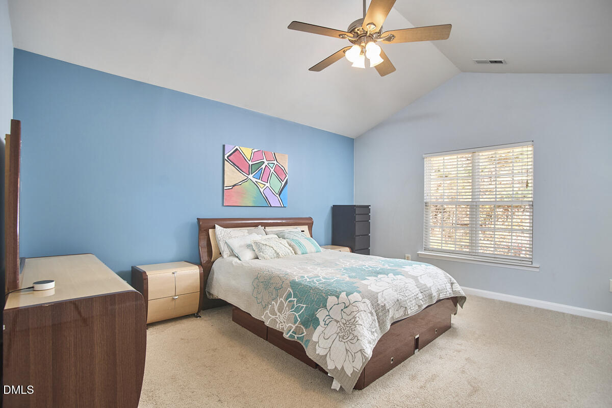 8441 Lunar Stone Place Raleigh, NC 27613 - Photo 28 of 43 a bedroom with a bed and a chandelier