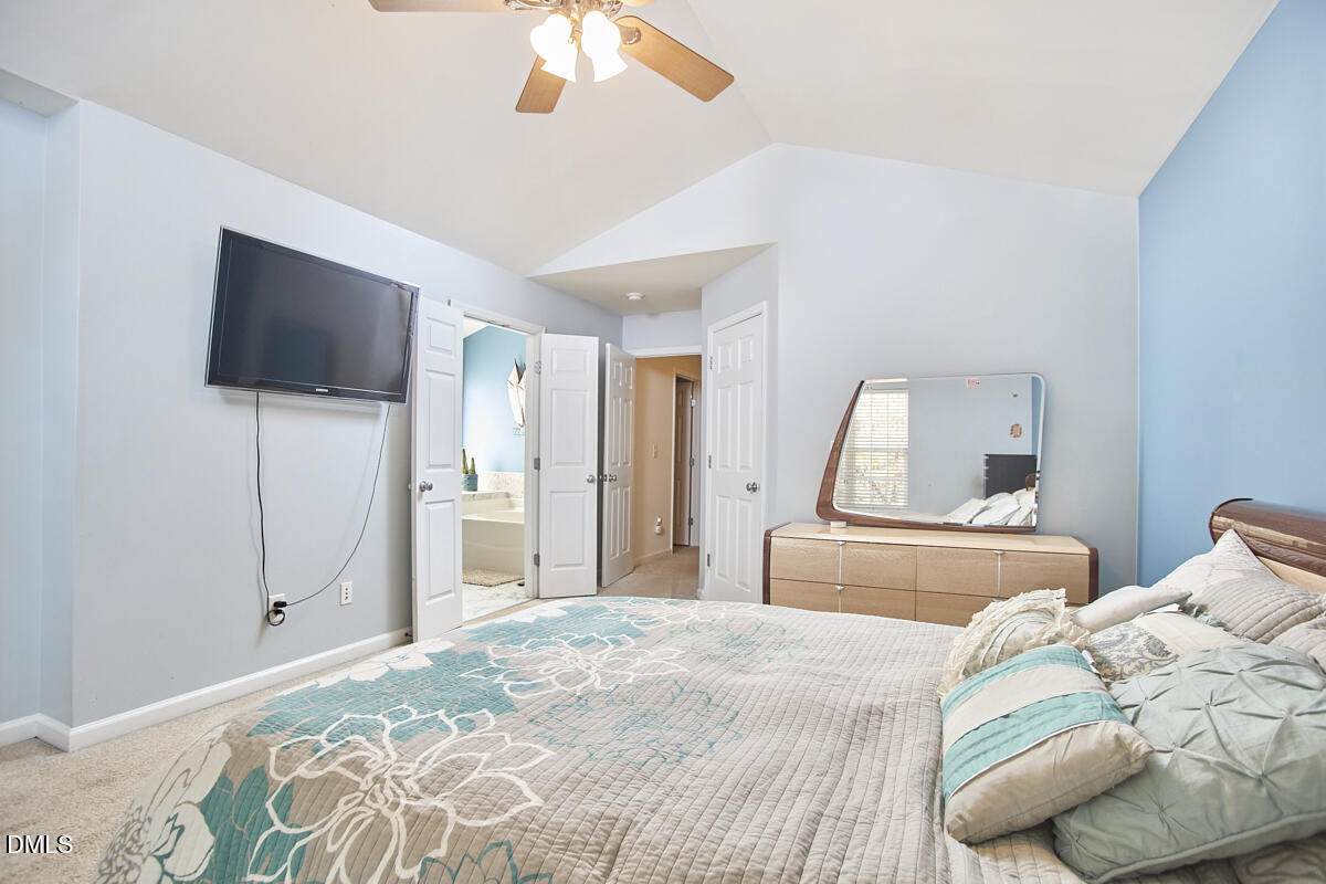 8441 Lunar Stone Place Raleigh, NC 27613 - Photo 29 of 43 a bedroom with a bed and a flat screen tv