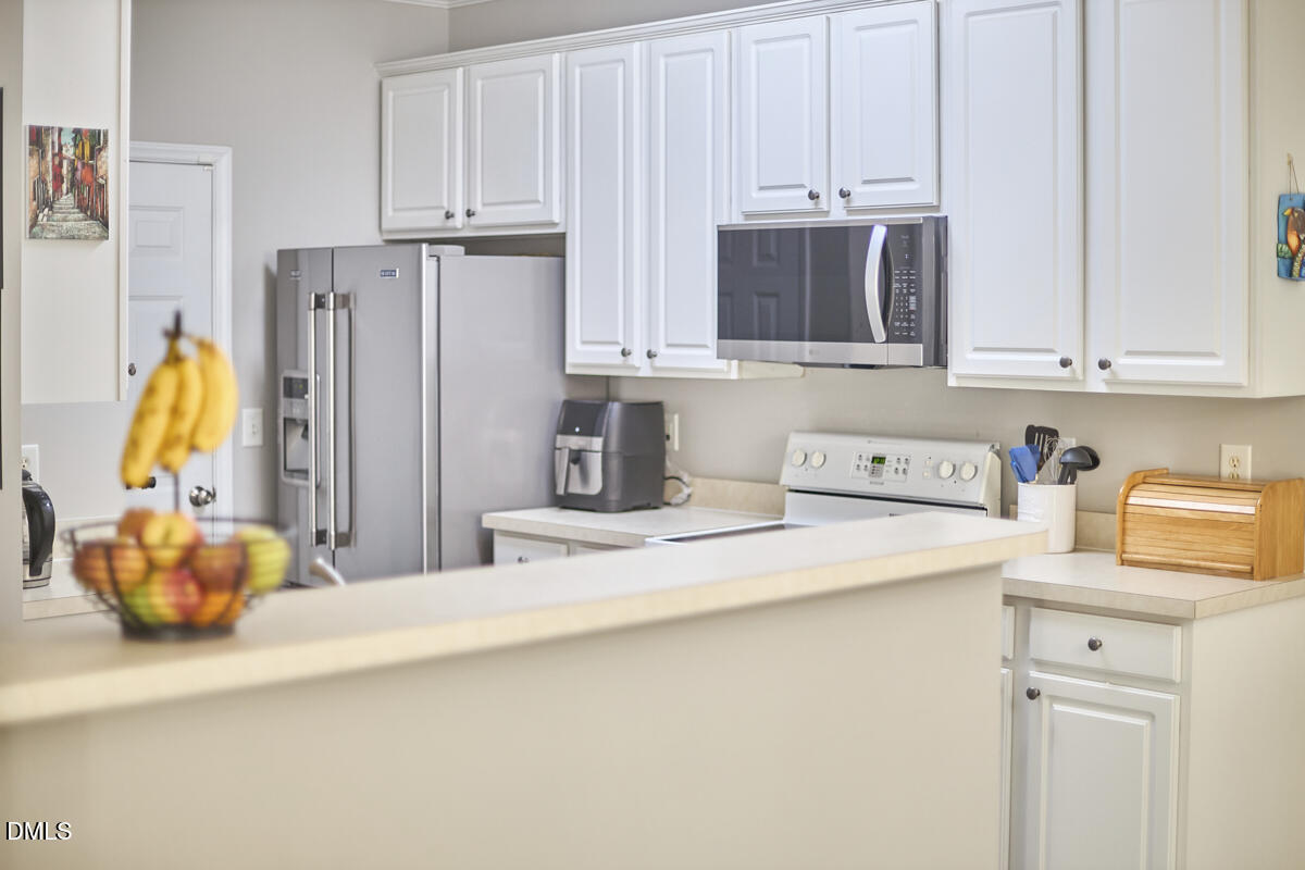 8441 Lunar Stone Place Raleigh, NC 27613 - Photo 41 of 43 a kitchen with stainless steel appliances granite countertop a refrigerator and a stove