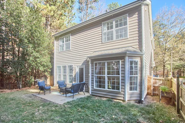 a view of a house with a backyard and sitting area