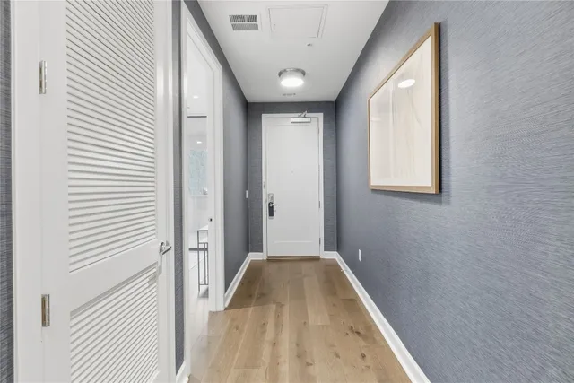 a kitchen with kitchen island white cabinets a sink dishwasher and a stove with wooden floor