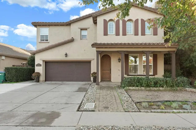 a front view of a house with a garden