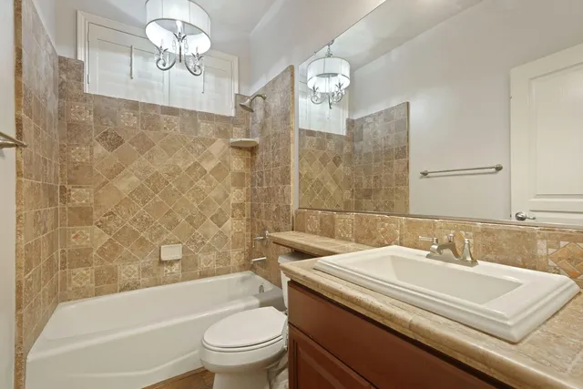 a bathroom with a sink a toilet a mirror a bathtub and shower