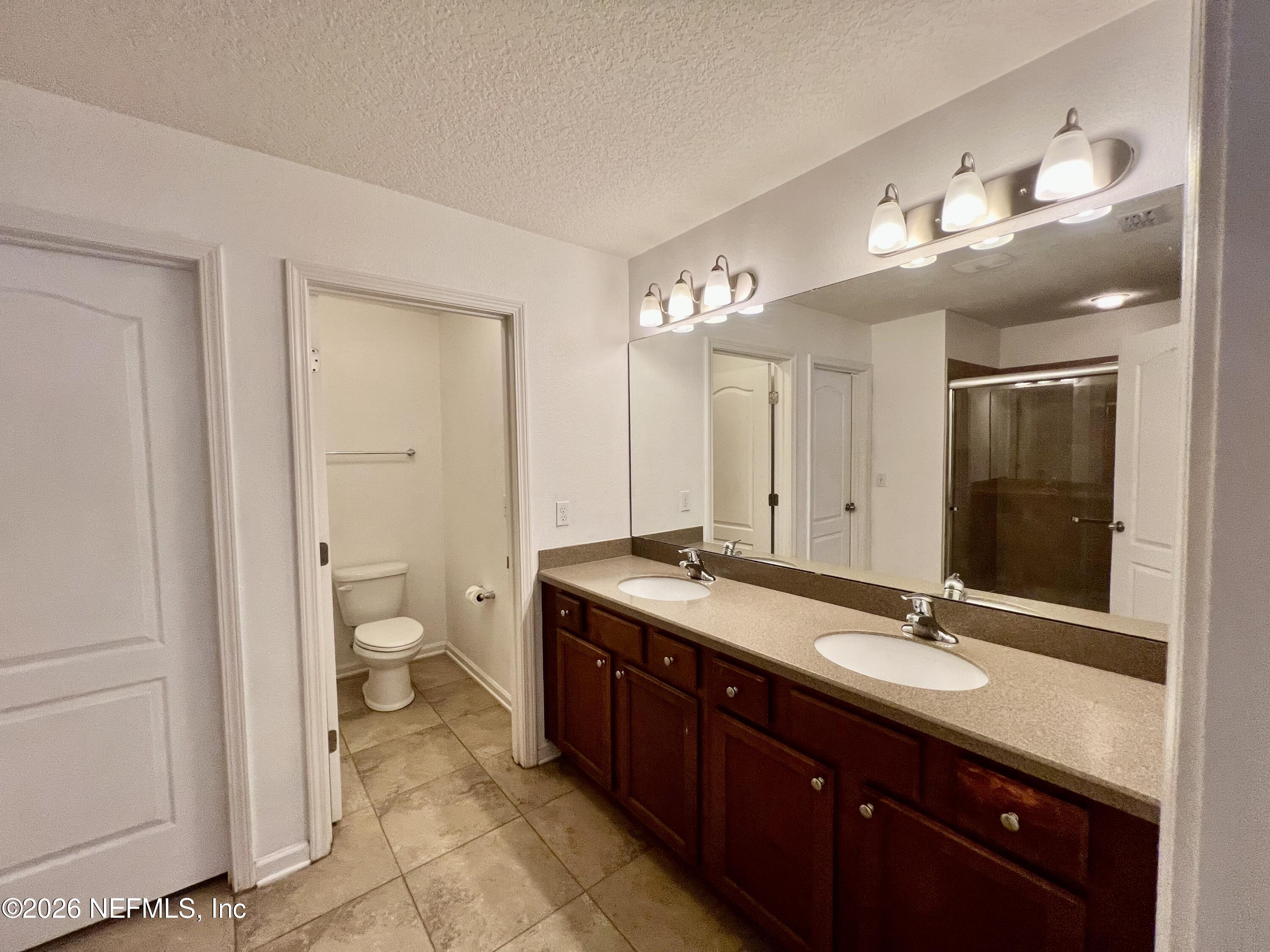 16264 Tisons Bluff Road Jacksonville, FL 32218 - Photo 17 of 36 a spacious bathroom with a granite countertop sink a mirror and a toilet