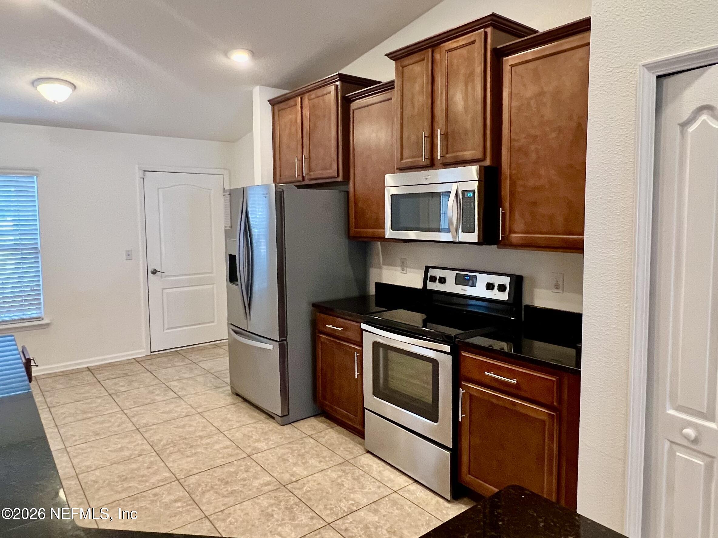16264 Tisons Bluff Road Jacksonville, FL 32218 - Photo 8 of 36 a kitchen with stainless steel appliances granite countertop a refrigerator stove and microwave