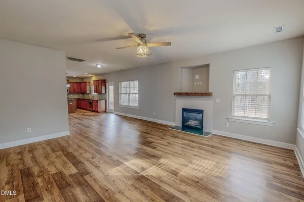 wooden floor fireplace and windows in an empty room