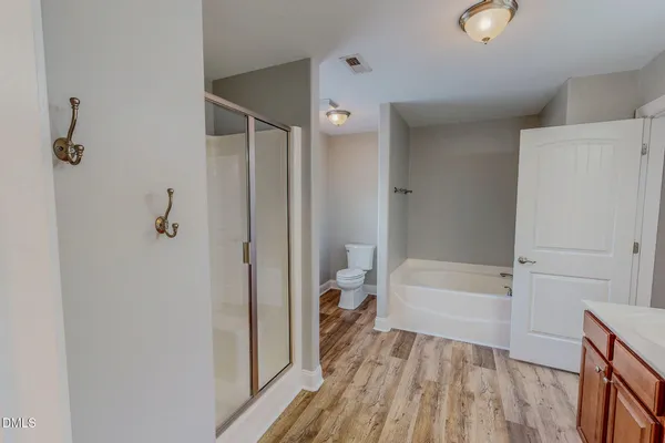 a view of a hallway with wooden floor and closet
