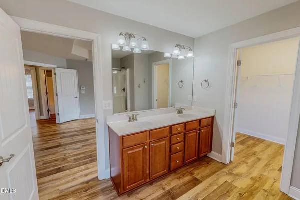 a view of a hallway with wooden floor and a living room