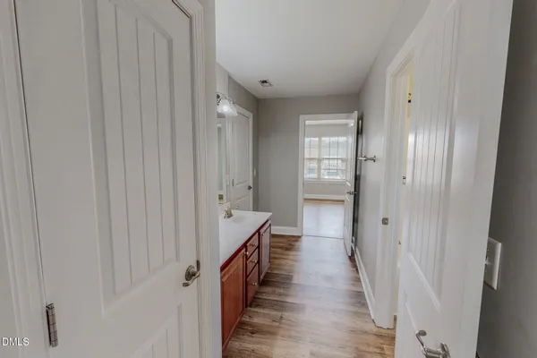 a view of a hallway with wooden floor and closet