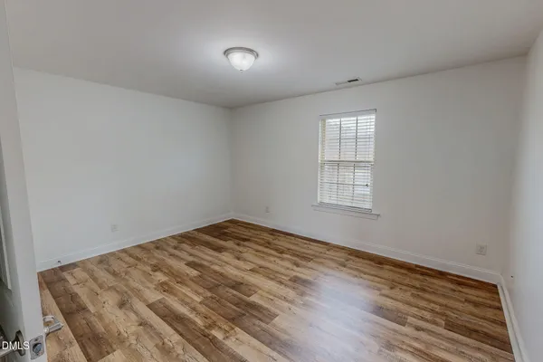 a view of an empty room with wooden floor