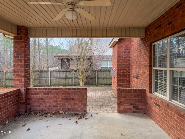 a view of an empty room with wooden floor fireplace and a window