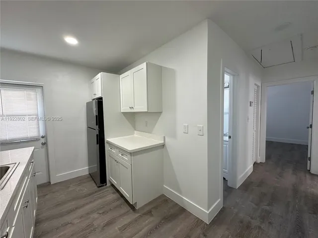 a kitchen with a refrigerator sink and cabinets