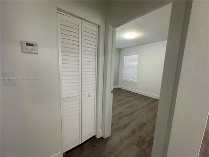 an empty room with wooden floor and closet