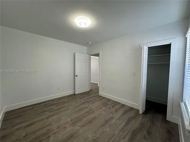 an empty room with wooden floor and closet