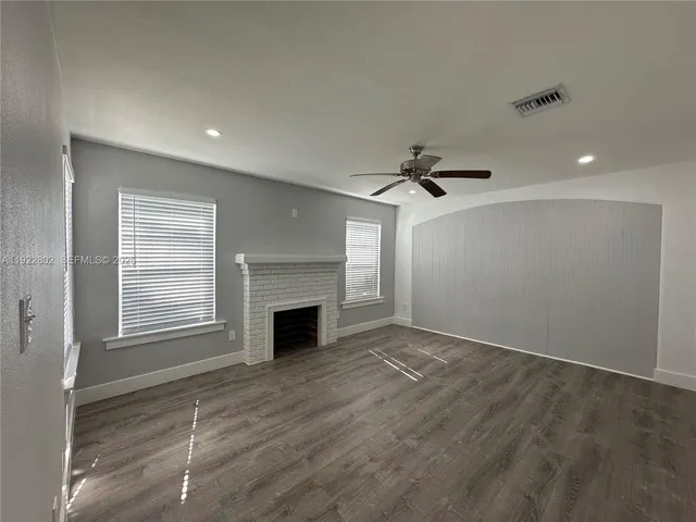 a view of an empty room with a fireplace and a window