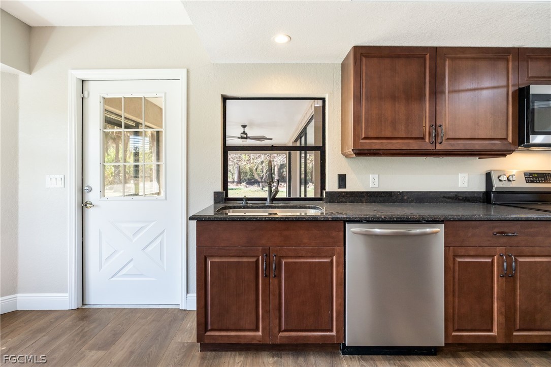 18890 Fox Run Road Alva, FL 33920 - Photo 11 of 50 a kitchen with stainless steel appliances granite countertop wooden cabinets and a granite counter tops