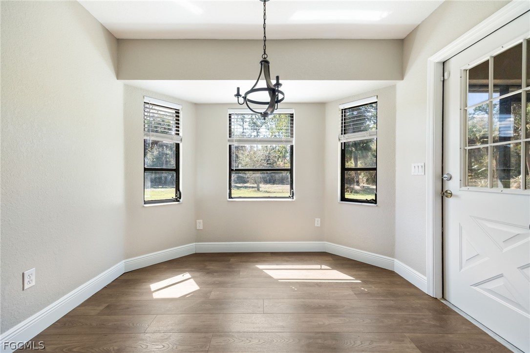 18890 Fox Run Road Alva, FL 33920 - Photo 14 of 50 a view of an empty room with windows and chandelier