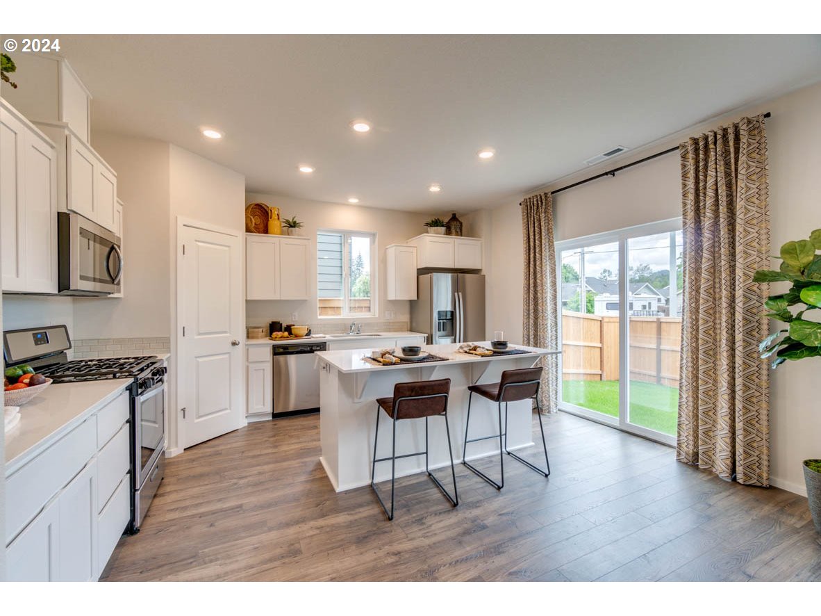 2967 V Street Springfield, OR 97477 - Photo 6 of 24 a kitchen with a table chairs microwave and cabinets