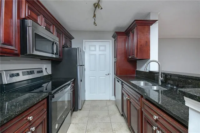 a kitchen with stainless steel appliances granite countertop a sink stove and refrigerator