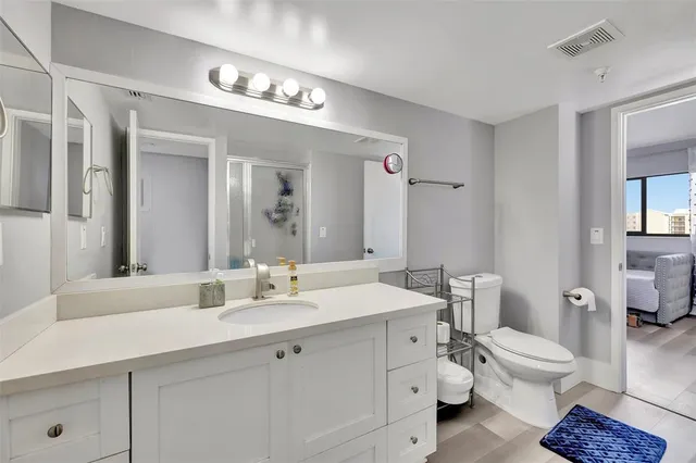 a bathroom with a double vanity sink mirror and toilet