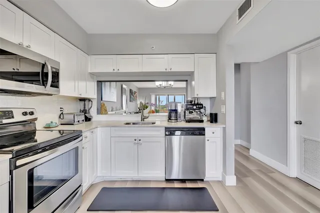 a kitchen with stainless steel appliances granite countertop a stove a sink and a refrigerator