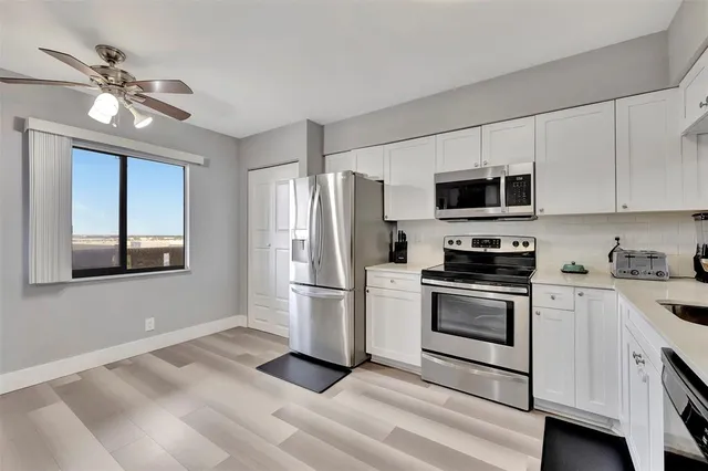 a kitchen with stainless steel appliances a stove microwave and refrigerator