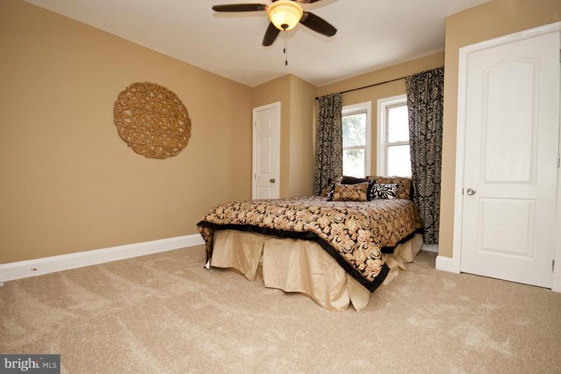 811 Wicklow Road Baltimore, MD 21229 - Photo 23 of 30 a bedroom with a bed and a chandelier