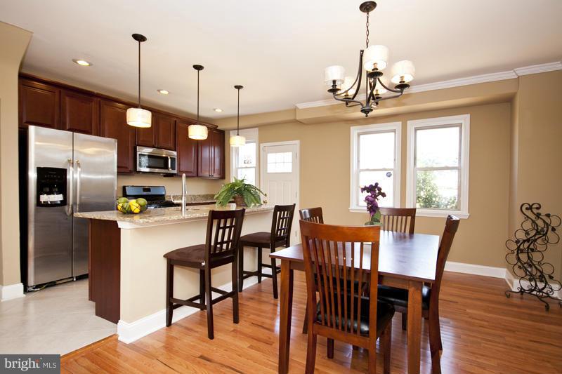 811 Wicklow Road Baltimore, MD 21229 - Photo 6 of 30 a view of a dining room and livingroom with furniture wooden floor a chandelier