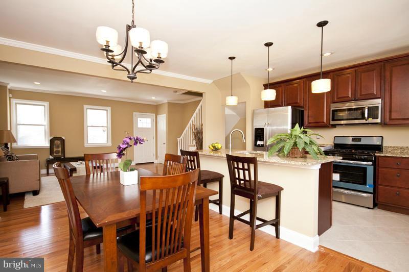 811 Wicklow Road Baltimore, MD 21229 - Photo 7 of 30 a view of a dining room with furniture a chandelier and wooden floor