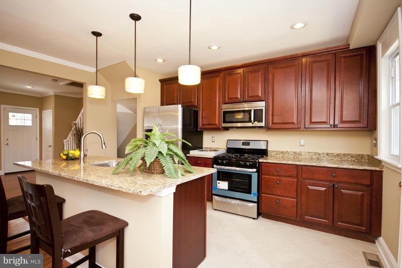 811 Wicklow Road Baltimore, MD 21229 - Photo 8 of 30 a kitchen with kitchen island granite countertop wooden cabinets and a stove