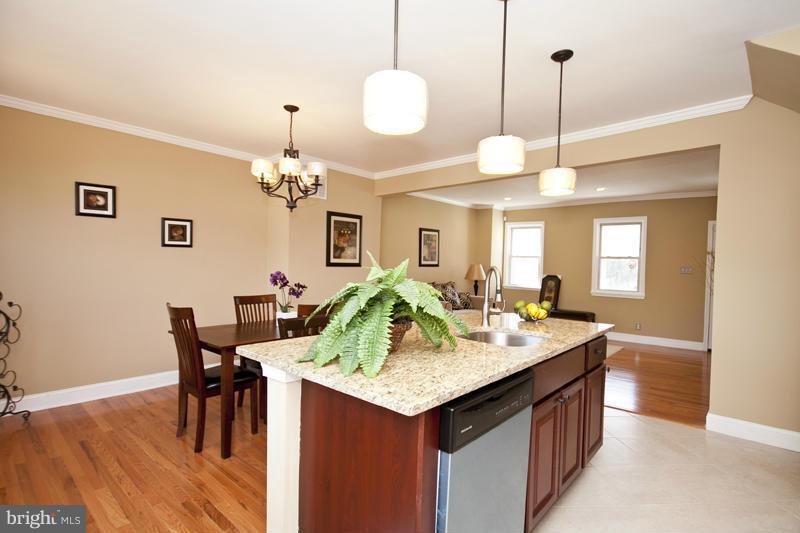 811 Wicklow Road Baltimore, MD 21229 - Photo 10 of 30 a kitchen island with granite countertop a dining table chairs and a chandelier