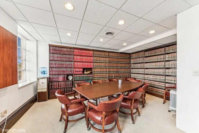 a dining room with furniture and a floor to ceiling window