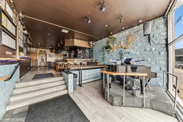 a living room with stainless steel appliances kitchen island granite countertop furniture and a fireplace