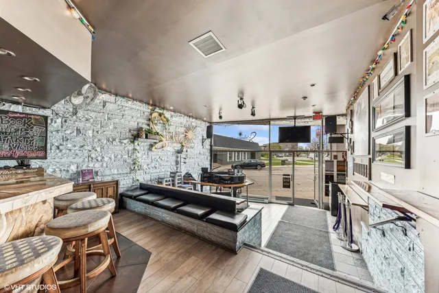 a living room with stainless steel appliances kitchen island granite countertop furniture and a fireplace