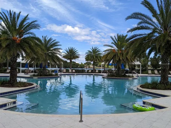 a view of swimming pool with outdoor seating and lake view