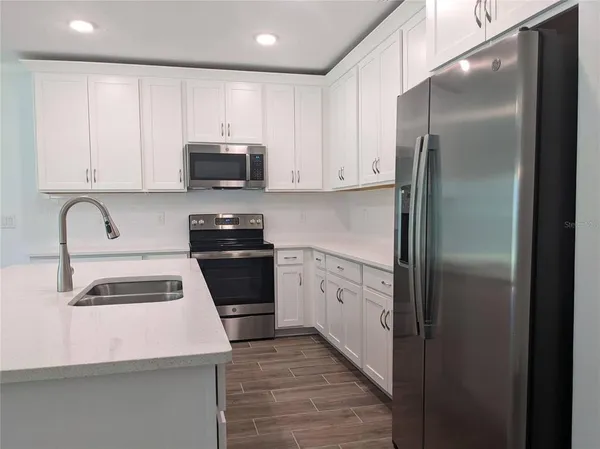 a kitchen with a refrigerator sink and cabinets
