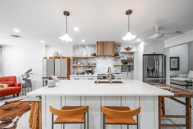 a kitchen with a dining table chairs and white cabinets