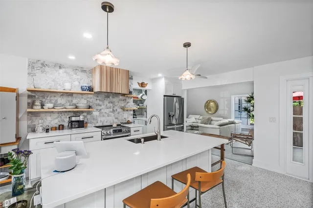 a kitchen with a sink a stove and chairs