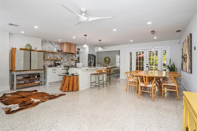 a kitchen with stainless steel appliances kitchen island granite countertop a table and chairs
