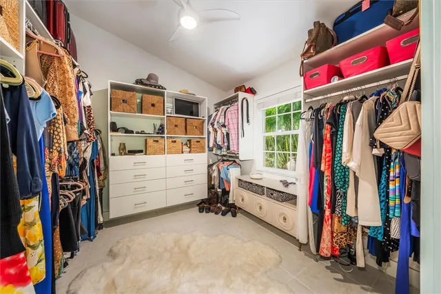 a view of walk in closet with clothes and shoes